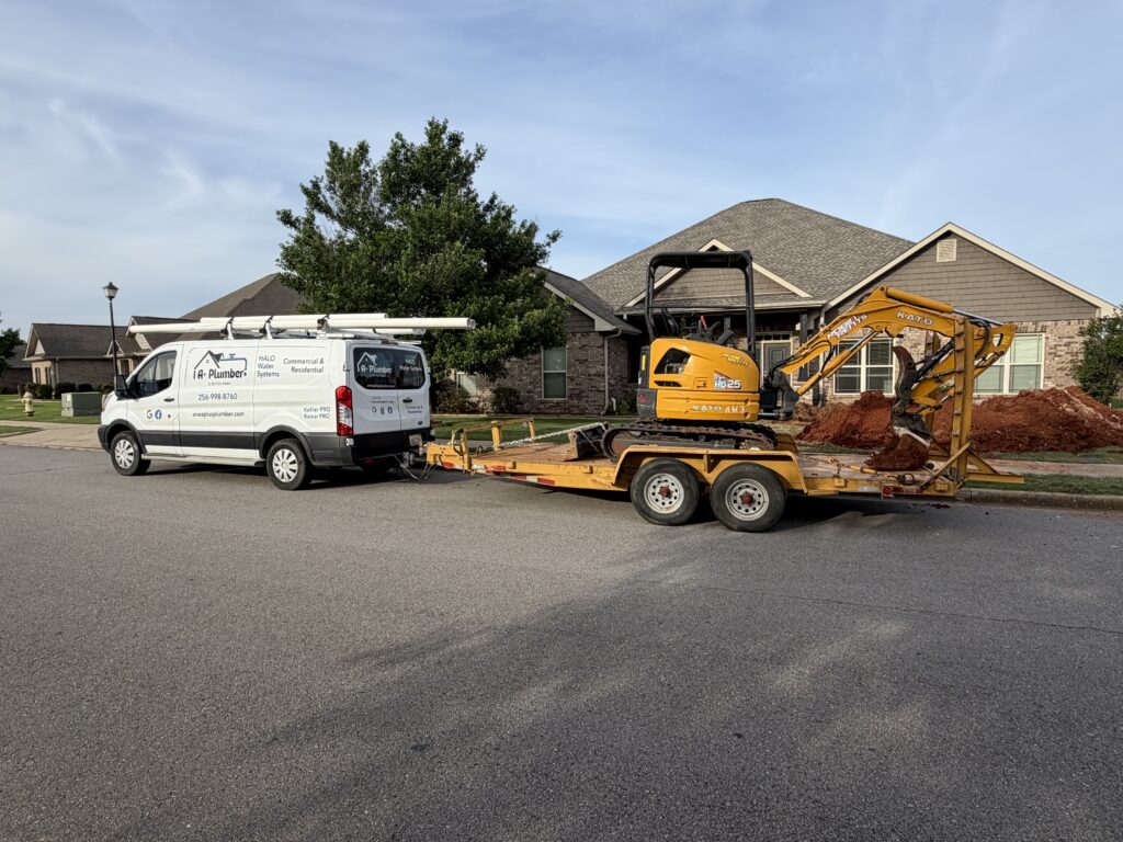 1 A+ Plumber emergency service truck, trailer, and mini excavator at a customer's home in Athens, AL providing emergency plumbing services.